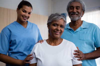 Portrait of smiling seniors with nurse in retirement home